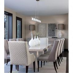 a dining room table with white chairs and a chandelier