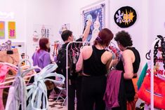 several women looking at clothing on racks in a room