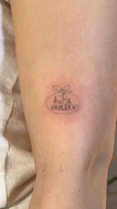 a person with a small tattoo on their arm that has a house in the middle