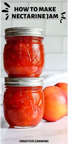 two jars filled with red liquid sitting on top of a table next to an apple