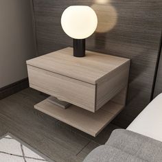 a night stand with a lamp on it next to a bed