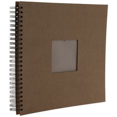 a brown spiral bound notebook with a white square in the middle