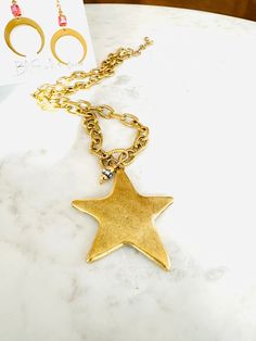 Introducing our stunning North Star statement necklace, which features a bold hammered 12k gold over brass star suspended from a chunky gold-plated brass chain. A dangle of Gold-plated beads with bezel set crystals have been added for a touch of sparkle. Handcrafted with precision and attention to detail, it’s the perfect accessory to add a touch of celestial charm to your look. Chain is adjustable and can be worn short 18 " or lengthened up to 21". The pendant adds additional 1.75 inches. Wear Gold Brass Necklace With Star Charm, Party Star-shaped Necklace With Adjustable Chain, Celestial Starburst Necklace With Star Charm, Celestial Star-shaped Gemstone Necklace, Celestial Star-shaped Nickel-free Necklaces, North Star Necklace, North Star, Brass Chain, Star Necklace