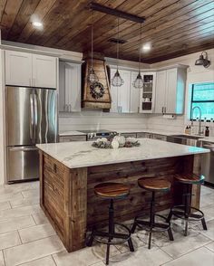 a kitchen with two stools at the island