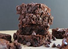 chocolate brownies stacked on top of each other with chocolate chips scattered around the edges