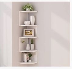 three white shelves with plants and vases on them in the corner of a room