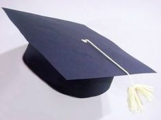 a graduation cap with a tassel hanging off it's side on a white surface