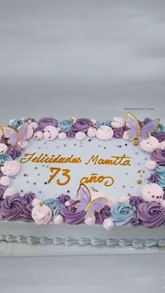 a birthday cake with purple frosting and butterflies on it's side is displayed