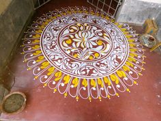 an intricately painted floor in the middle of a room with a metal cage on it