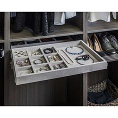 an open drawer in a closet filled with jewelry