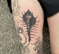 a woman's leg with tattoos on it and an octopus in the middle of her leg