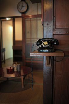 an old fashioned telephone sitting on top of a wooden table next to a coffee table