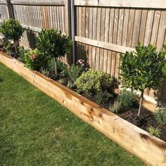 a wooden planter filled with lots of plants