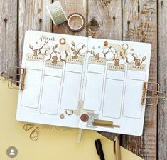 an open planner sitting on top of a wooden table