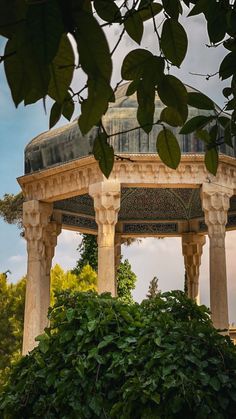 the gazebo is surrounded by greenery and trees