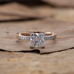 a diamond ring sitting on top of a leaf