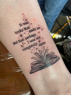 a person with a book tattoo on their arm