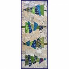 a quilted wall hanging with blue and green triangles on the front, along with white background