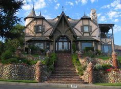 a large house with stone walls and steps leading up to it