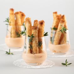 three small glasses filled with dipping sauce and appetizers