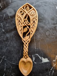 a wooden spoon sitting on top of a black table next to a marble countertop