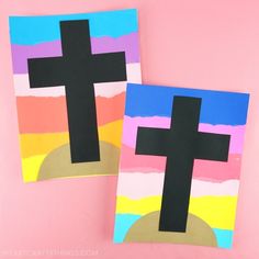 two cross paintings made from construction paper on pink background, one is black and the other is white