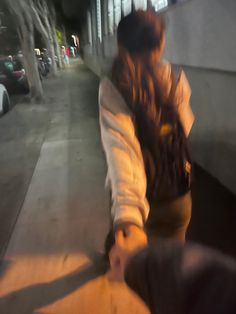 a blurry image of a woman walking down the street with her hand in her pocket