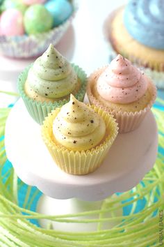 cupcakes with frosting and sprinkles are on a cake plate