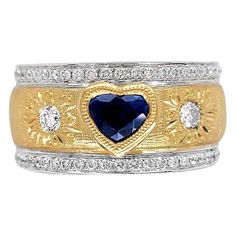 Produced by award winning Italian designer Stefano Vitolo. Stefano creates custom artisanal one of a kind jewelry with excellent gemstones in a truly old world Italian craftmanship. This handcrafted ring has 0.81 total carat weight of F/G color and VS clarity diamonds. Center Stone Heart Shape Blue Sapphire 0.75 carat. Band width 10 mm. Available also in 18 Karat Yellow, White or Pink on request. Yellow Gold Multi-stone Jewelry For Anniversary, Anniversary Multi-stone Yellow Gold Jewelry, Exquisite Heart Cut Gemstone Jewelry, 14k Gold Fusion Jewelry For Anniversary, Heirloom Heart Cut Gemstone Jewelry, Elegant Wide Band Gemstone Jewelry, Heirloom Sapphire Ring With Diamond Gemstone Accents, Heart Cut Sapphire Jewelry With Diamond Accents, Heart Cut Multi-stone Diamond Rings