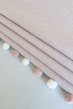 four pieces of pink and white fabric with pom - poms on the edge