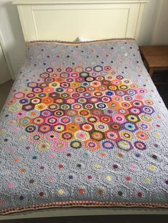 a crocheted blanket is sitting on a bed