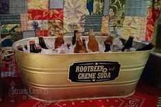 a tub filled with bottles of beer on top of a red tablecloth covered floor