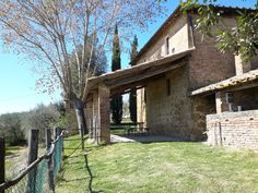 an old brick house with a fence around it and trees in the yard next to it