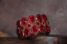 "Beautiful bracelet with red rhinestone crystals, great statement piece! Pageant, prom, or bridal! Size: 1.6\" wide Style: stretch bracelet color: red crystals Base Metal color: gold Looking for matching earrings or necklace? Browse through our listings or send us a message! :) https://www.etsy.com/listing/551764936/red-rhinestone-necklace-and-earrings-set?ref=shop_home_active_15 https://www.etsy.com/listing/550716625/red-and-ab-rhinestone-earrings-red-large?ref=shop_home_active_50 Looking for t Red Bracelet, Fun Ornaments, Red Bracelets, Earrings Red, Red Rhinestone, Rhinestone Bracelet, Red Crystals, Rhinestone Necklace, Crystal Bracelet