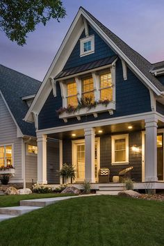 a house that is lit up at night with lights on the front and side windows