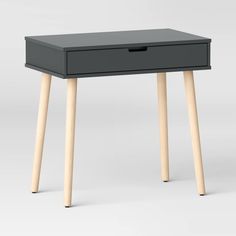 a black table with two wooden legs and a drawer on the top that is open