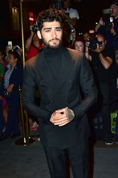 a man in a black suit and tie at an event