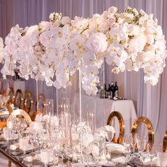 a table is set with white flowers and candles