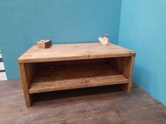 a wooden table sitting on top of a hard wood floor next to a blue wall