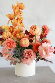 an arrangement of flowers in a vase on a table