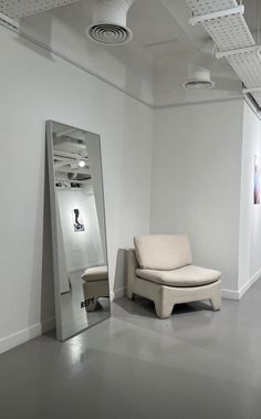 an empty room with a chair and mirror