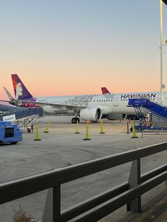 an airplane is parked on the runway at sunset