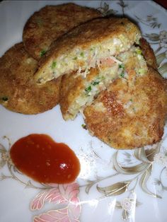 two fried food items on a plate with ketchup and condiments next to it