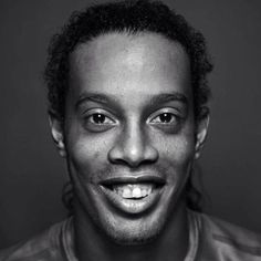 a black and white photo of a man smiling at the camera with an intense look on his face