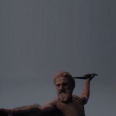 a man with a knife in his hand standing next to a statue