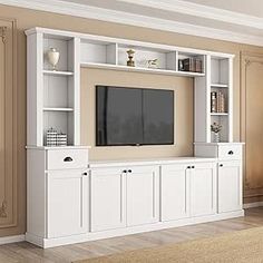 a white entertainment center with built - in bookshelves and cabinets on each side