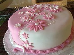 a pink and white cake with flowers on it