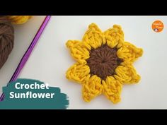 the crochet sunflower is next to yarn