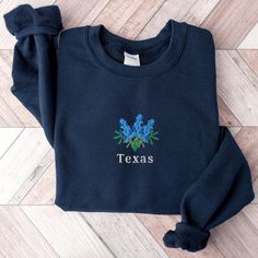 Navy Embroidered Cotton Tops, Blue Tops With Custom Embroidery For Spring, Blue Crew Neck Top With Custom Embroidery, Blue Embroidered Tops For Winter, Blue Embroidered Crew Neck Top, Winter Blue Tops With Embroidered Graphics, Blue Tops With Embroidered Graphics For Winter, Fitted Blue Top With Embroidered Logo, Winter Blue Tops With Letter Embroidery