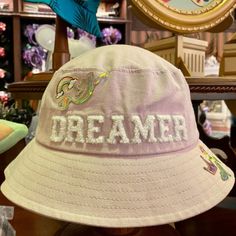 Disney Parks Princess Dreamer Lilac-Lavender Bucket Hat. Adorable And Super Cute Princess Dreamer Theme Bucket Hat. Lilac-Lavender Color. Fuzzy White "Dreamer" Lettering. Holographic Ariel With Rainbow. Cinderella Crown And Slipper. Belle's Rose. New With Tags! * One Size * Shell: 100% Cotton * Lining: 95% Polyester, 5% Cotton Smoke Free Home Cinderella Crown, Monsters University Hat, Mickey Mouse Ears Hat, Mermaid Hat, Blue Bucket Hat, Blue Stockings, Disney Minnie Mouse Ears, Christmas Beanie, New Disney Princesses